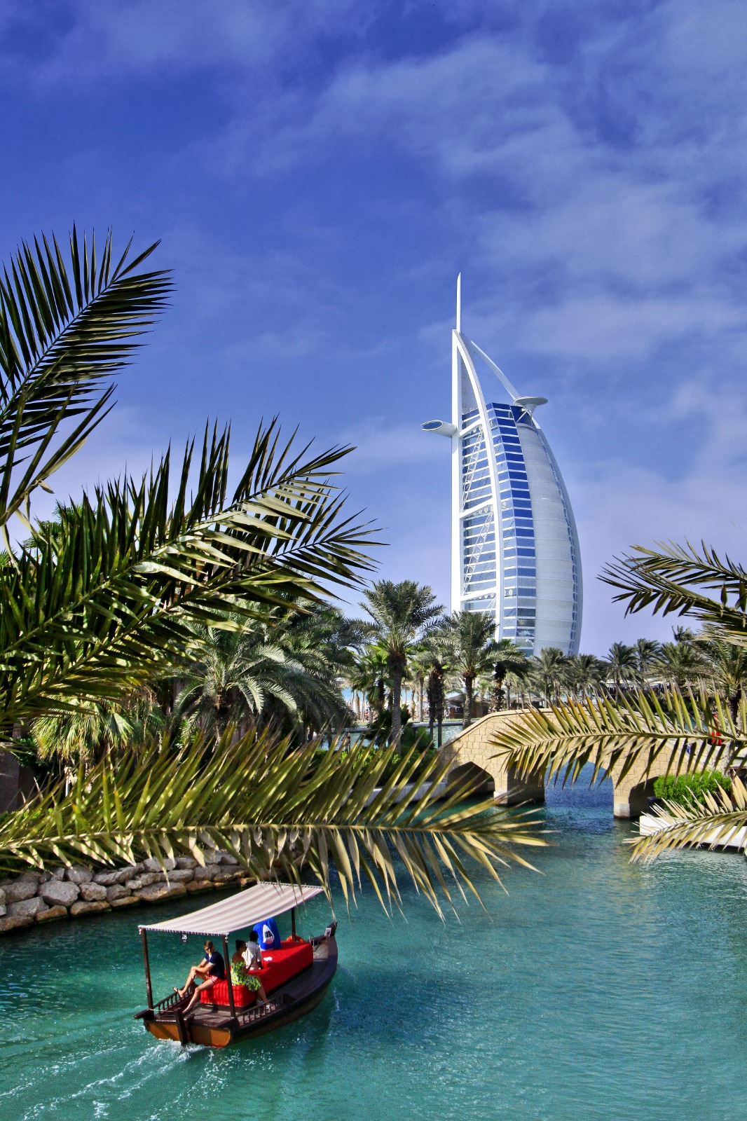 Iconic sail-shaped hotel framed by palm trees and water